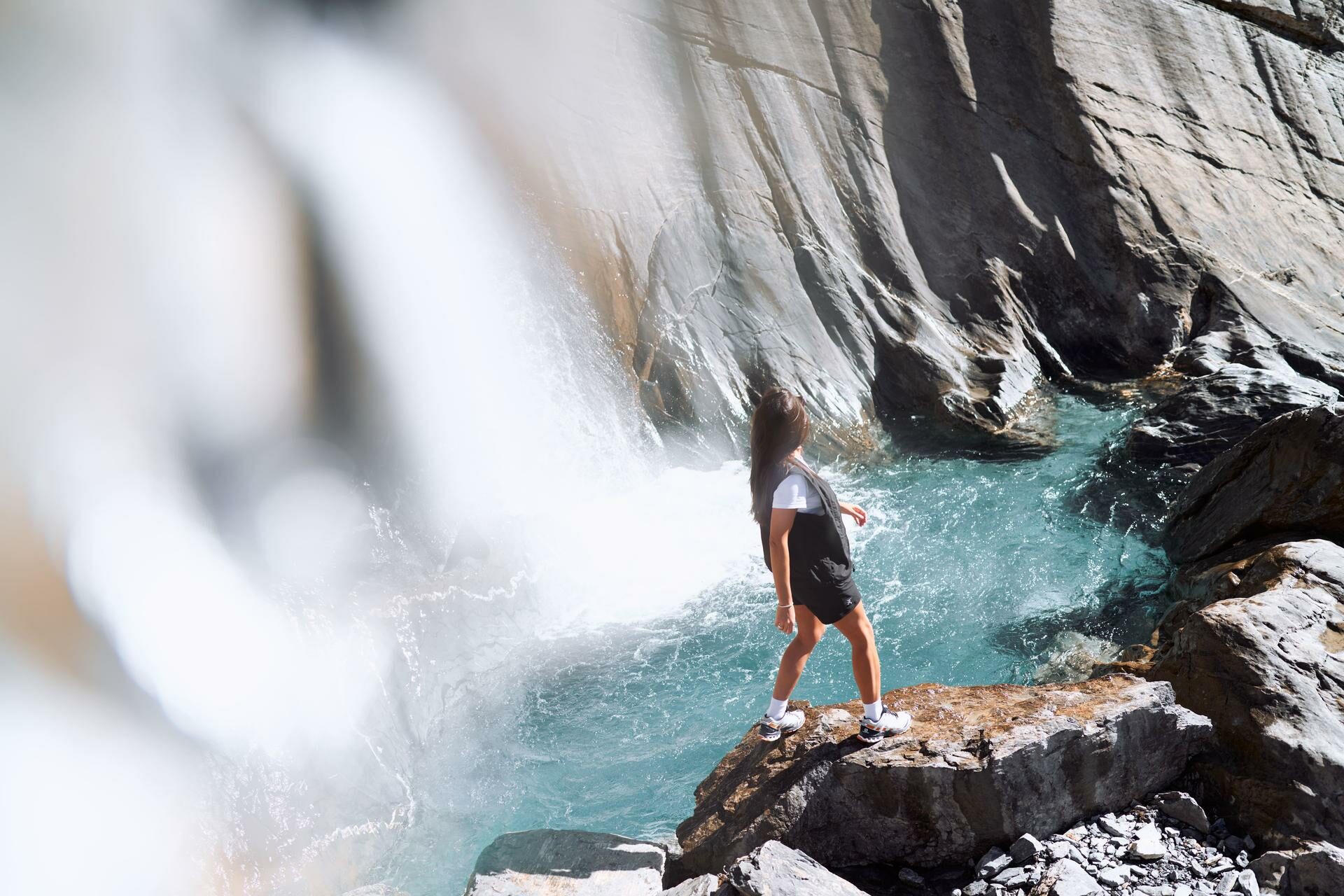 Frau die am Wasserfall beim Segnesboden steht.